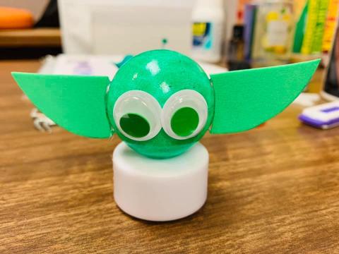 a small ping pong ball that has been colored green with google eyes to look like Yoda. It sits on a battery operated tea light candle to light up.