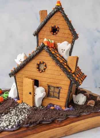 Gingerbread house with marshmallow ghosts, candy corn, creepy frosting. 