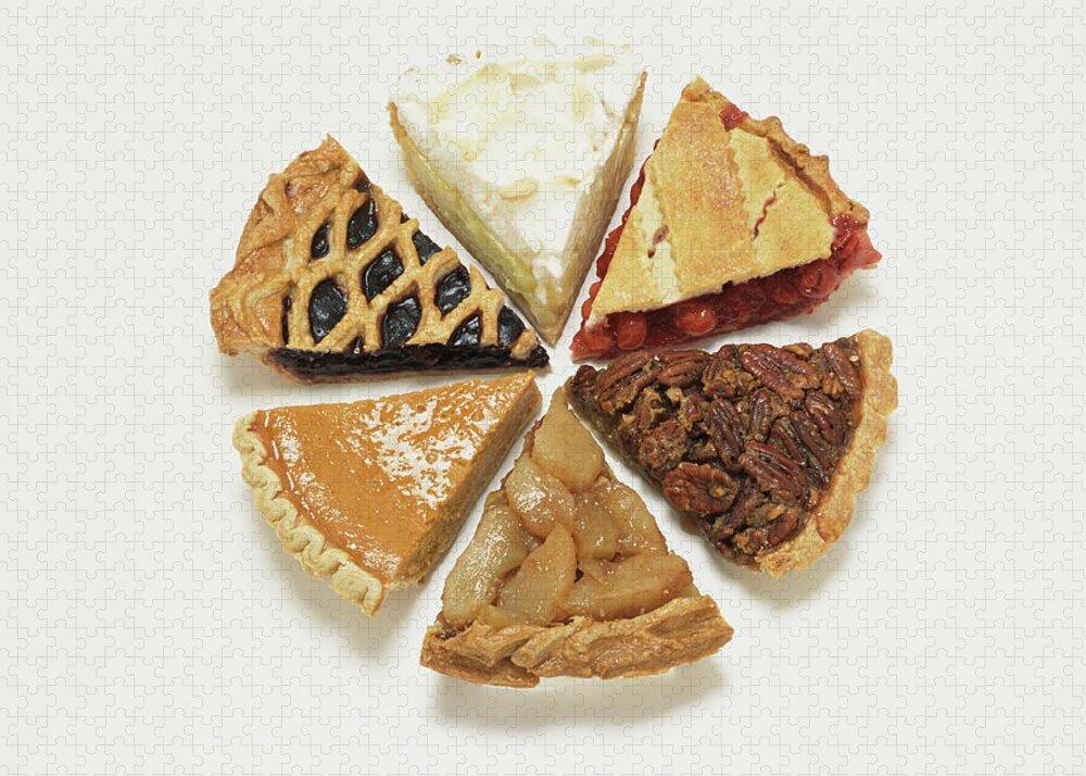 a white puzzle with different slices of pie that are part of the puzzle picture. 